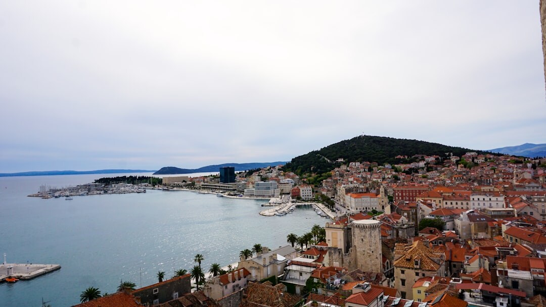Photographer with camera overlooking Split's rooftops from a bell tower